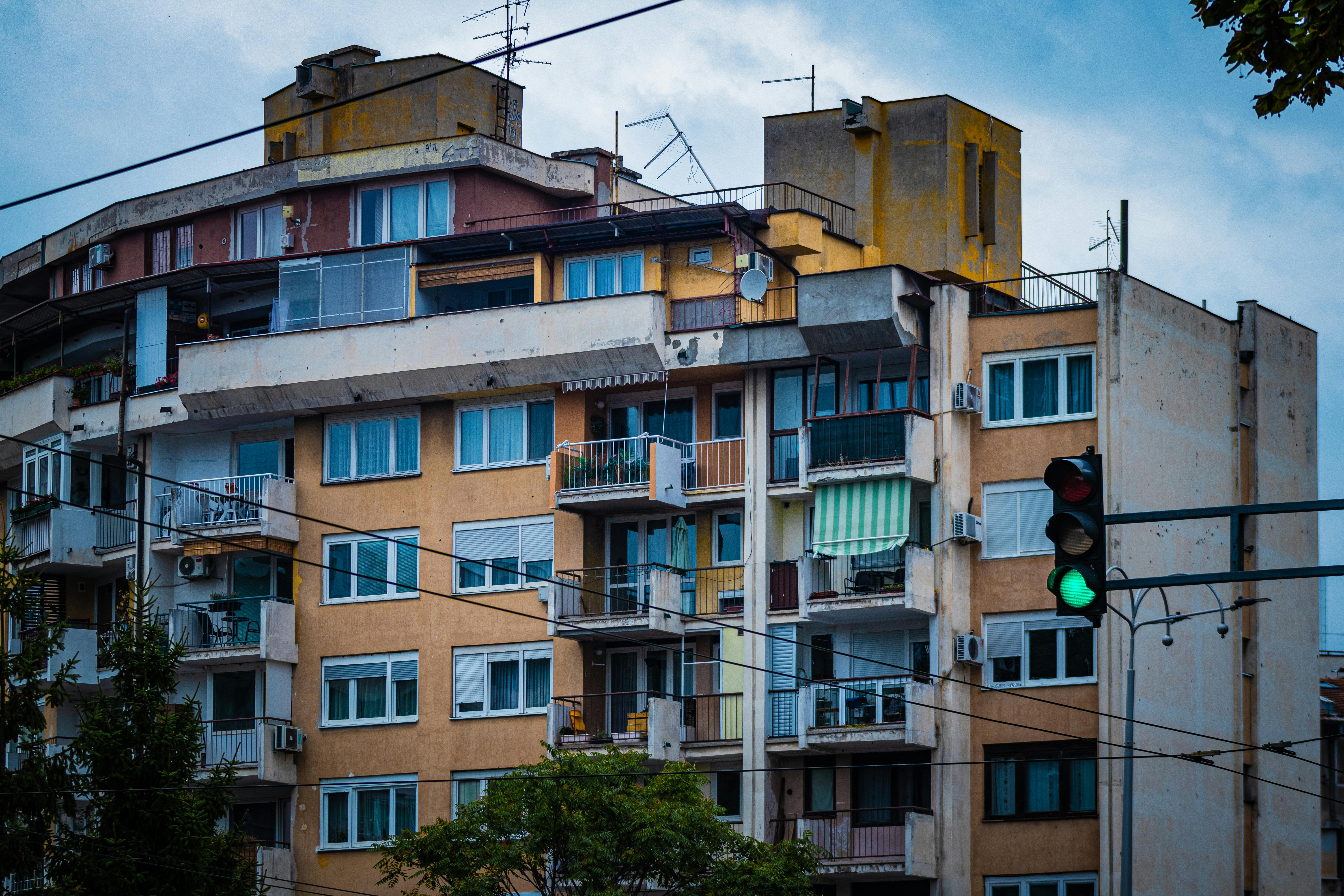 Residential building with balconies and traffic light at green signal.