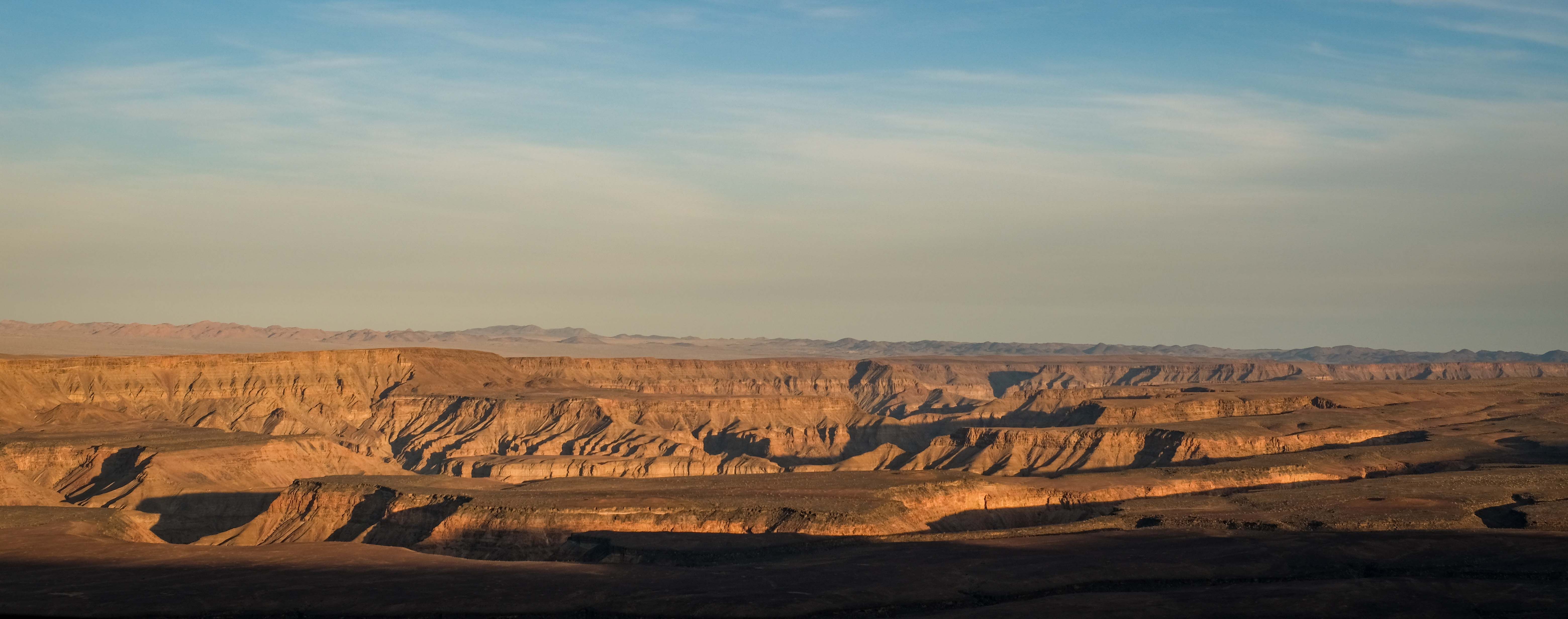 Stunning panoramic view of a desert canyon under a clear sky, highlighting natural beauty.