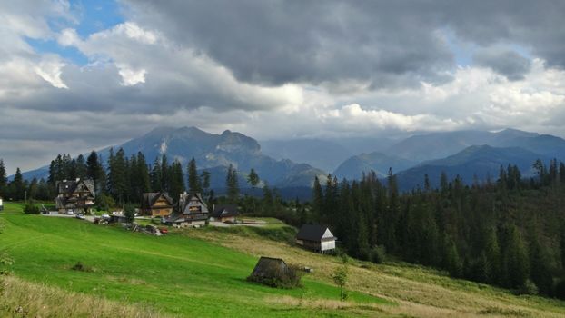 波兰布科维纳·塔特拉扎耶夫斯卡风景如画的山区，拥有传统的房屋、郁郁葱葱的田野和多云的天空