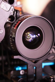 Detailed view of a 24mm T1.5 cinema lens on a professional video camera rig.