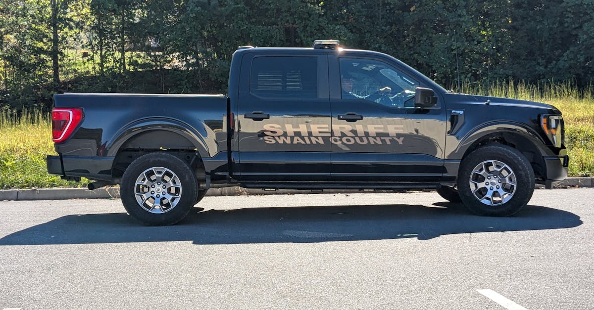 Photo by R9 Media Photo Collective Swain County Sheriff pickup truck parked outdoors in daylight. Side view capture.