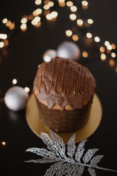 Delicious chocolate-covered panettone with festive lights, perfect for the holiday season.