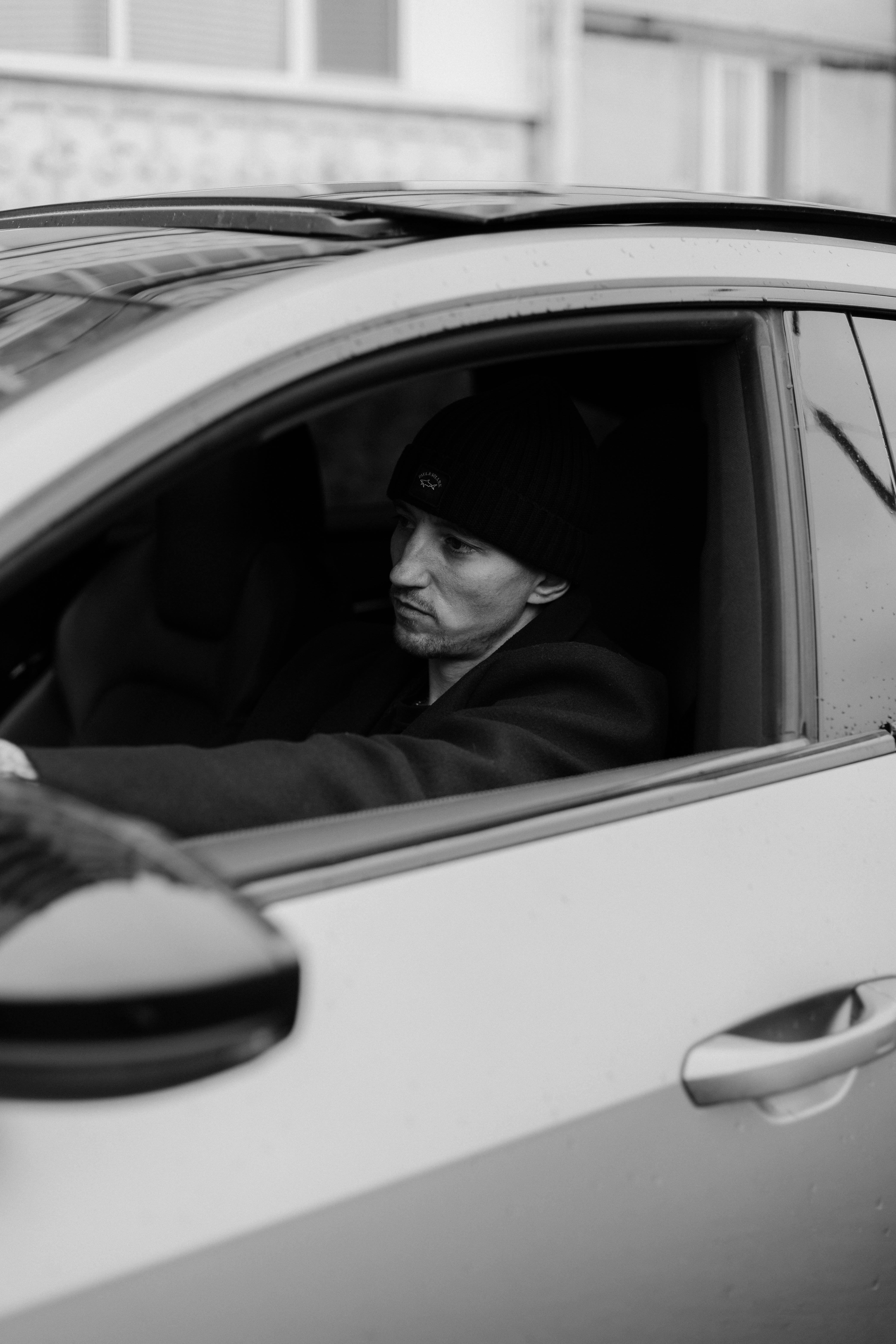 Free Monochrome photo of man in a car with thoughtful expression. Stock Photo