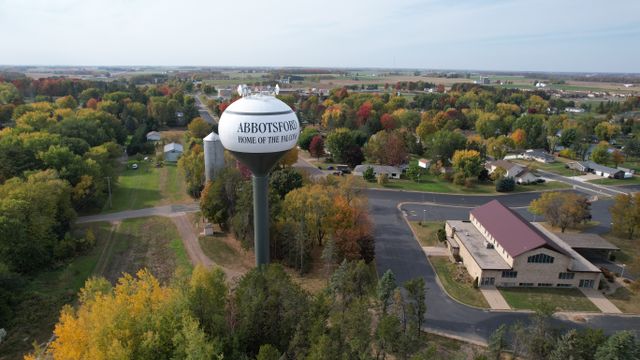 Scenic aerial view of Abbotsford, Wisconsin with fall foliage and a water tower.