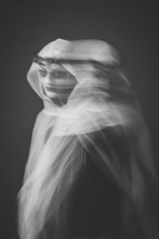 Enchanting double exposure portrait with ghostly veil in monochrome.