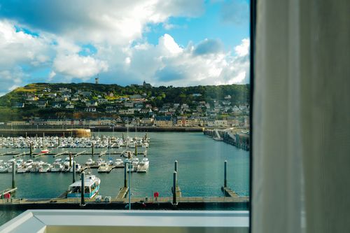 Free Beautiful coastal town and harbor view from a window with boats and blue sky. Stock Photo