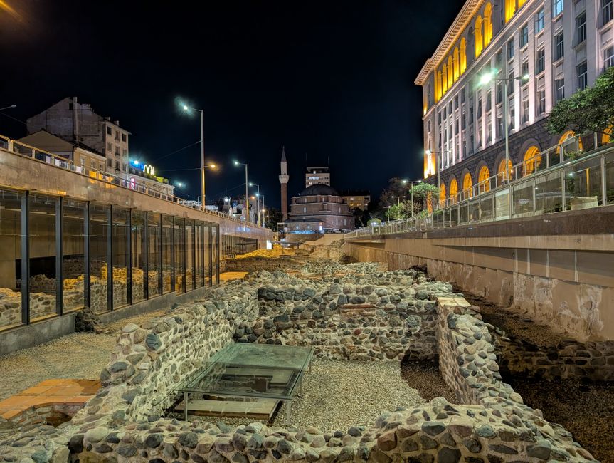 Illuminated Serdica ruins and Sofia buildings at night, Bulgaria.