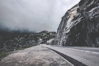 雾气缭绕的瑞士风景中，一条空荡荡的山路蜿蜒穿过，非常适合旅行和冒险主题