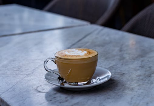 A beautifully crafted artisan coffee in a serene cafe atmosphere on a marble table.