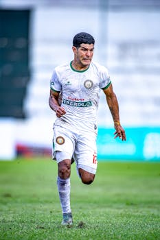 Intense action shot of a male soccer player running on the field.