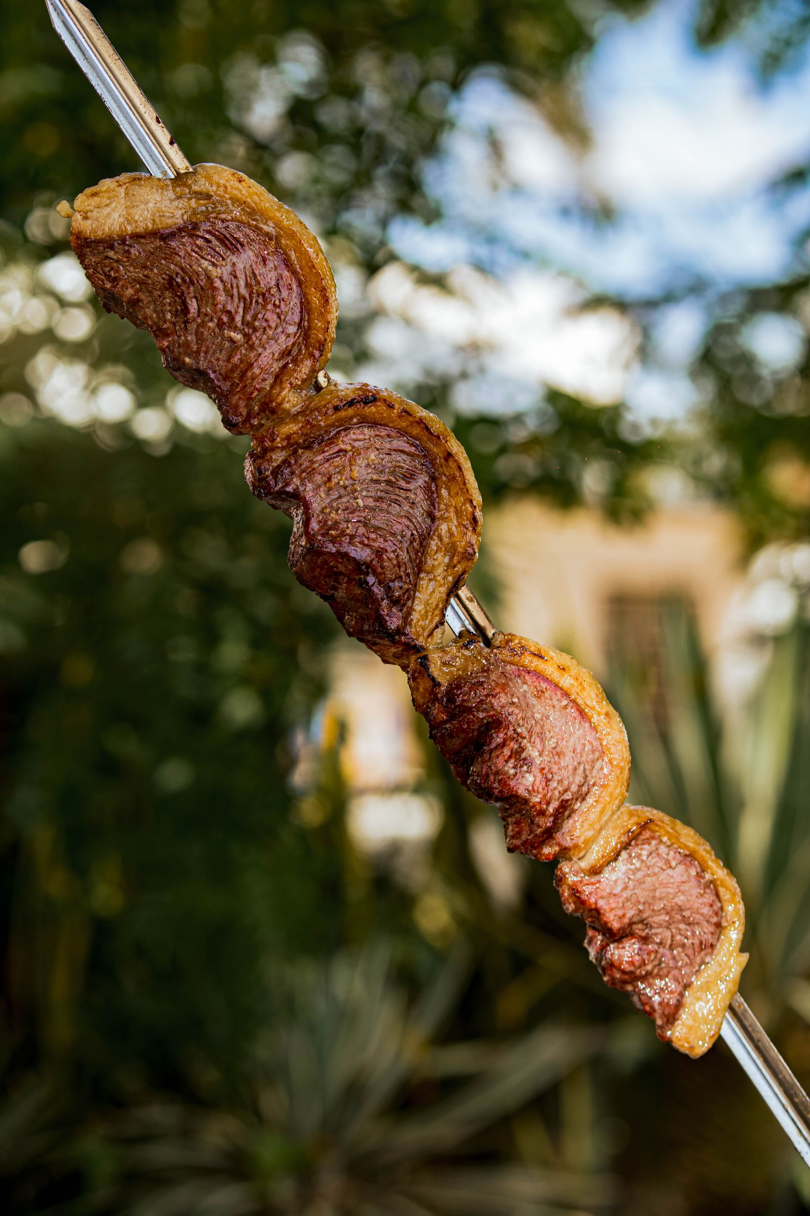 Juicy Brazilian picanha pieces roasted on a traditional skewer