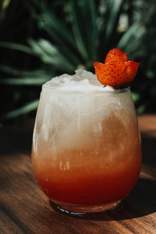 Free Delicious strawberry cocktail with a frothy top, garnished with a fresh strawberry slice. Stock Photo