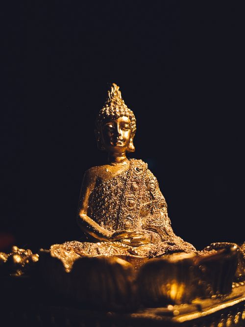 Free Golden Buddha statue surrounded by darkness, emphasizing serenity. Stock Photo