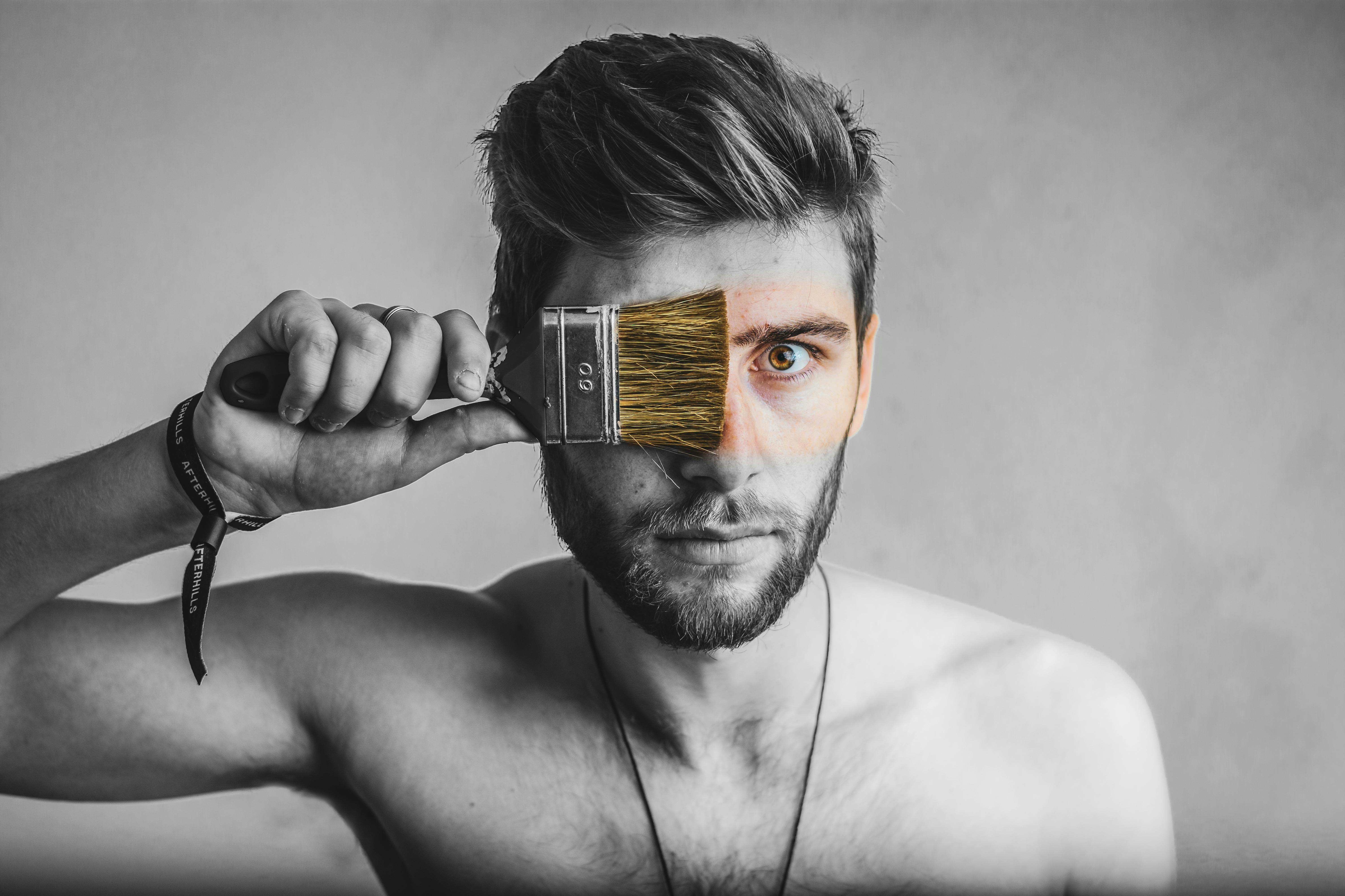 gray scale photo of man holding brush