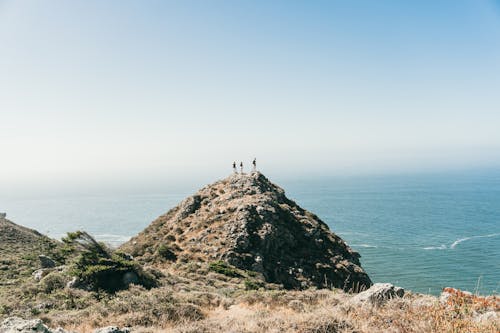 Free People Standing on Cliff Edge Stock Photo
