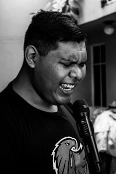 Dynamic black and white portrait of a singer passionately performing outdoors.
