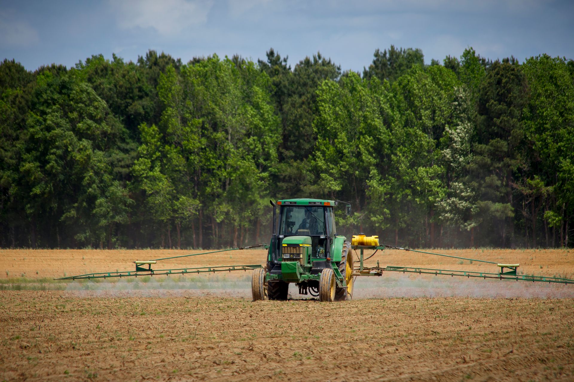 Un pulverizador agrícola trabajando en un campo de cultivo