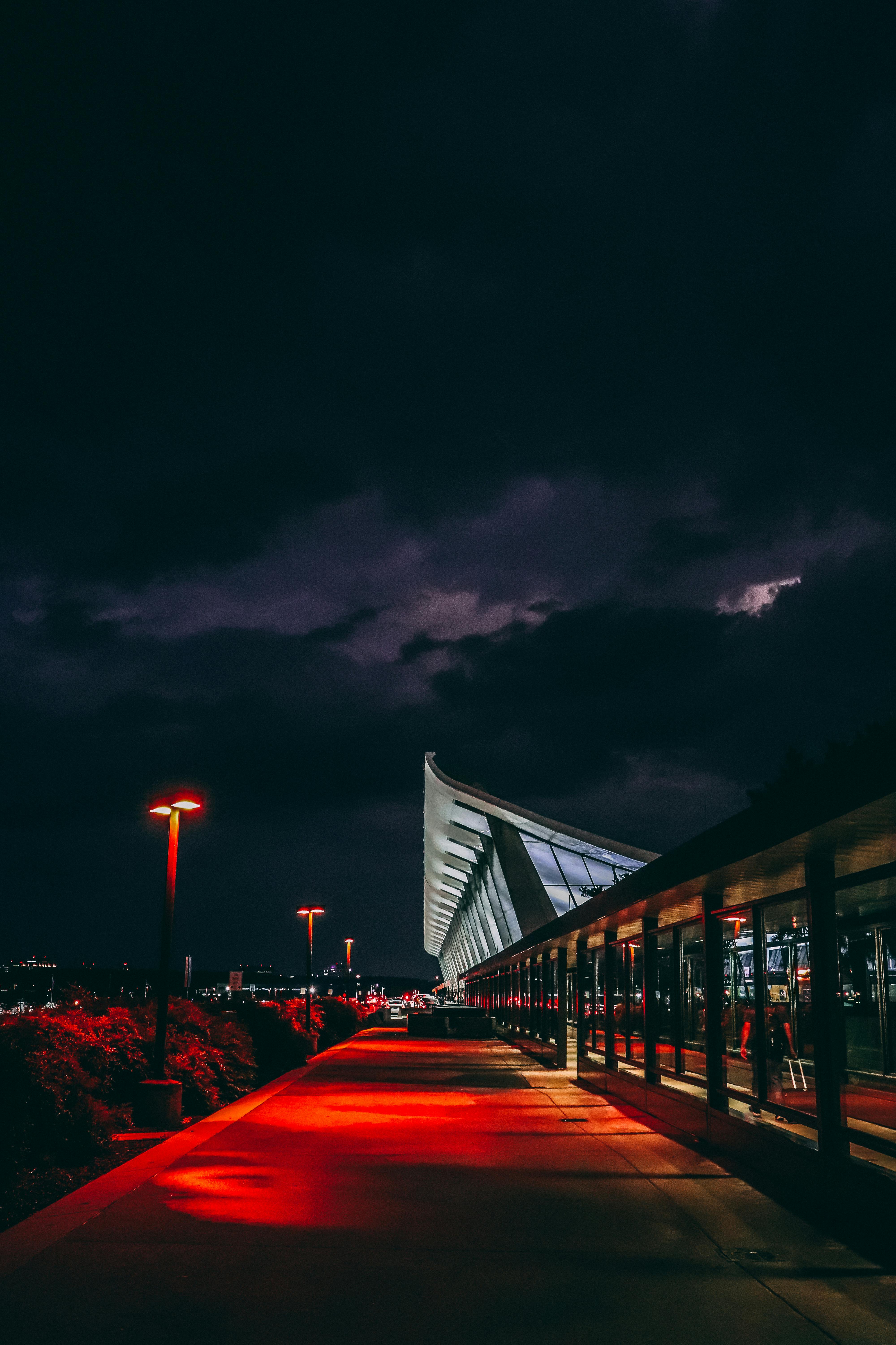 white and gray building under black cloudy sky at night time