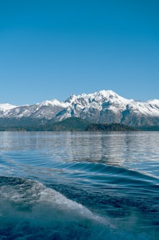Stunning view of snow-capped Andes mountains reflecting on Lake Nahuel Huapi, Argentina.