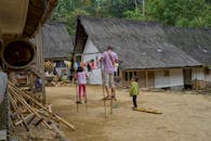 Traditional Village Scene with Children on Stilts