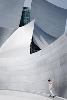 Sleek metallic architectural structure with a lone woman walking.