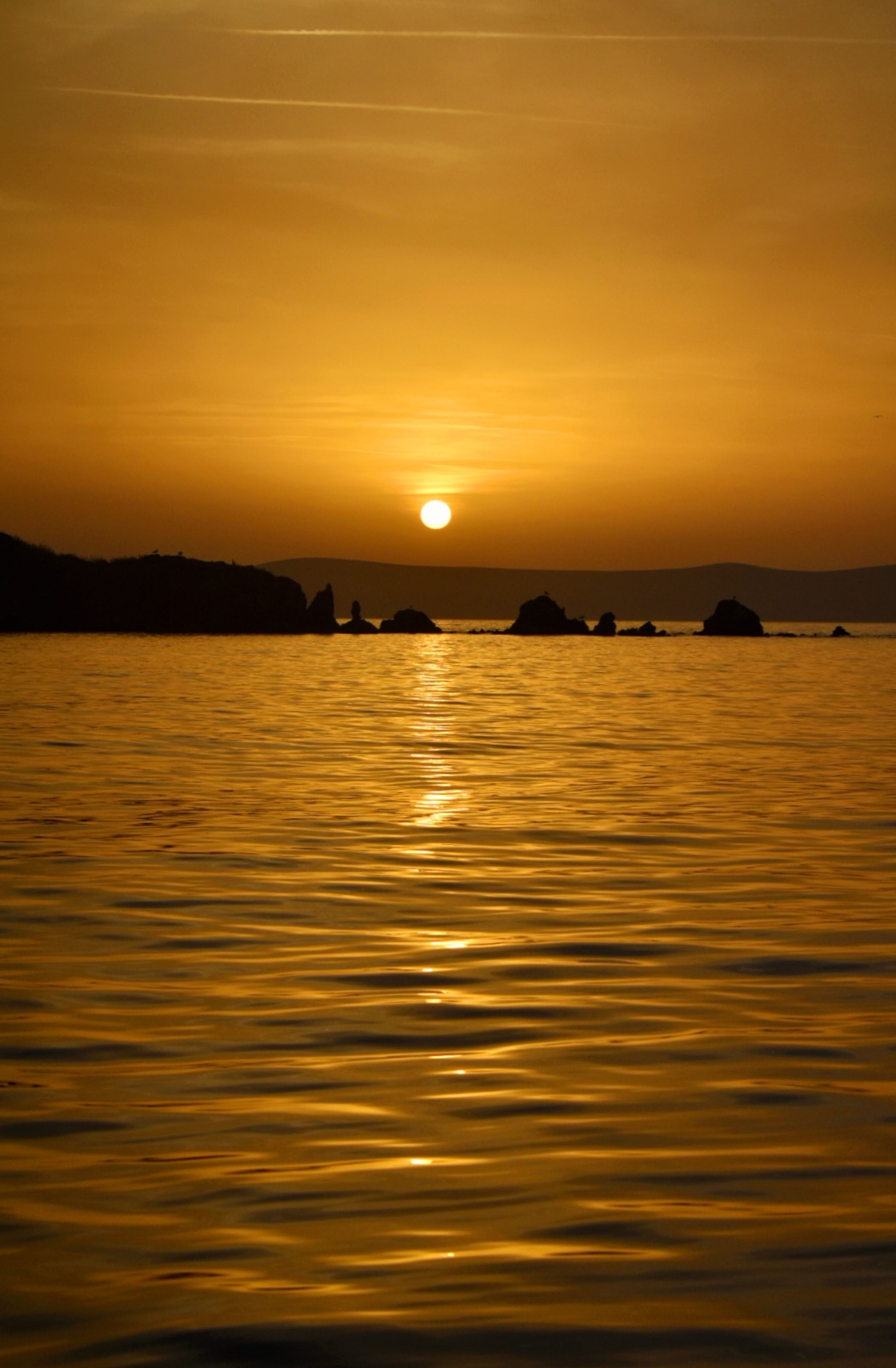 Serene Golden Sunset Over Calm Ocean Waves · Free Stock Photo