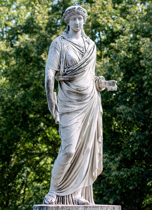 Free Elegant marble statue of a woman in an outdoor park setting. Stock Photo