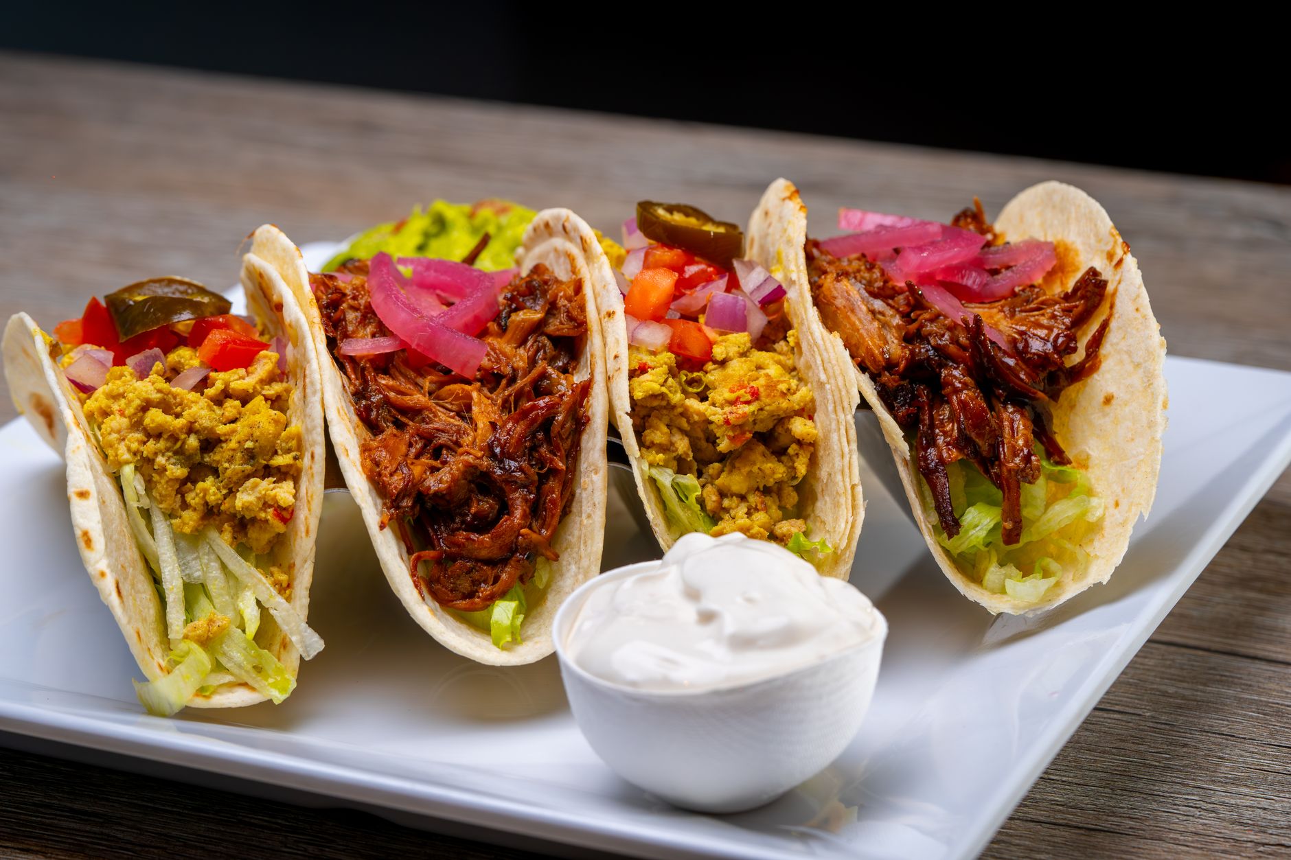 Your Ultimate Weekly Meal Plan for Stress-Free Dinners Four flavorful tacos with different fillings on a plate, perfect for a savory meal.