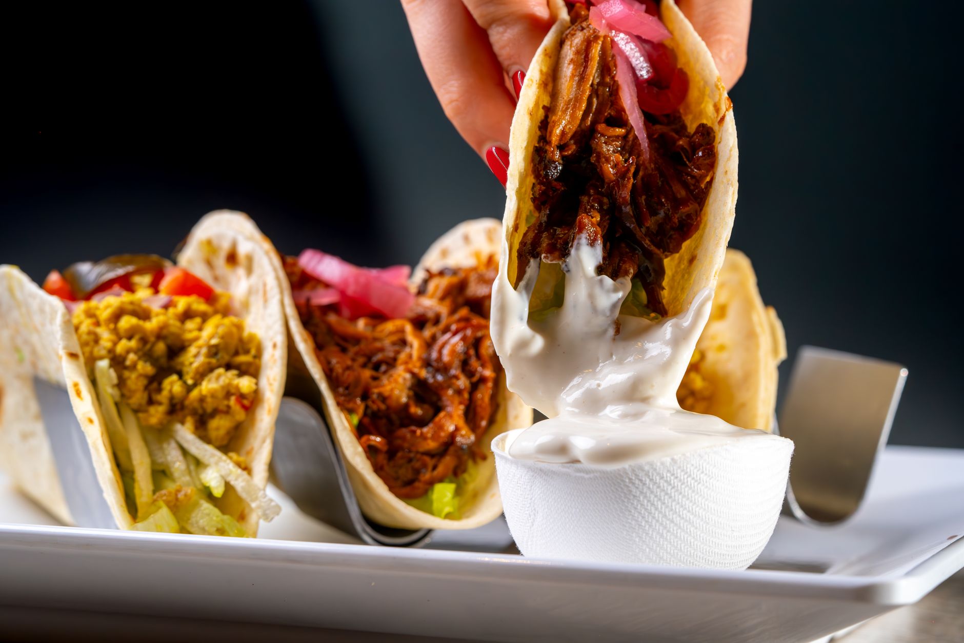 Close up of sour cream being spooned onto dish