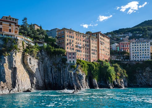 Charming old buildings atop rocky cliffs along Italy's Ligurian coastline on a sunny day. by pierre matile