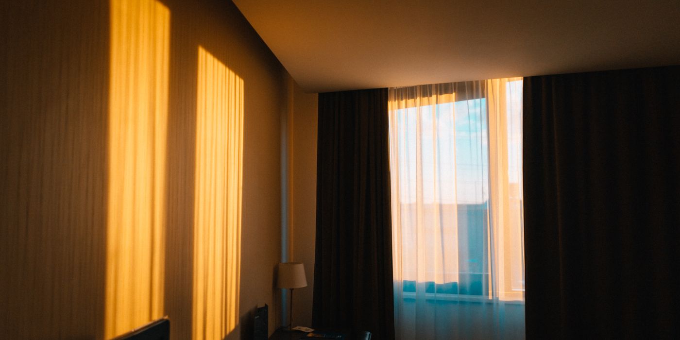 Neatly made hotel room with a double bed and bedside lamps