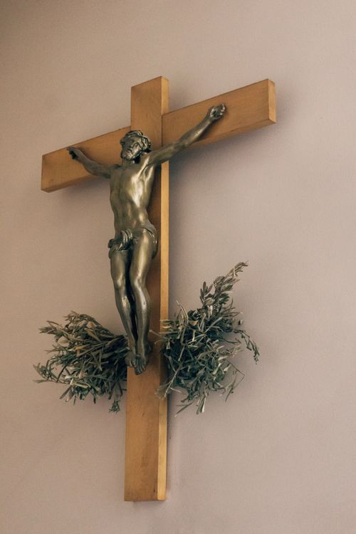 Free Elegant bronze crucifix on a wooden cross, capturing religious artistry. Stock Photo