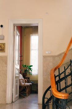 Bright room interior with wooden staircase and potted plant in sunlight.