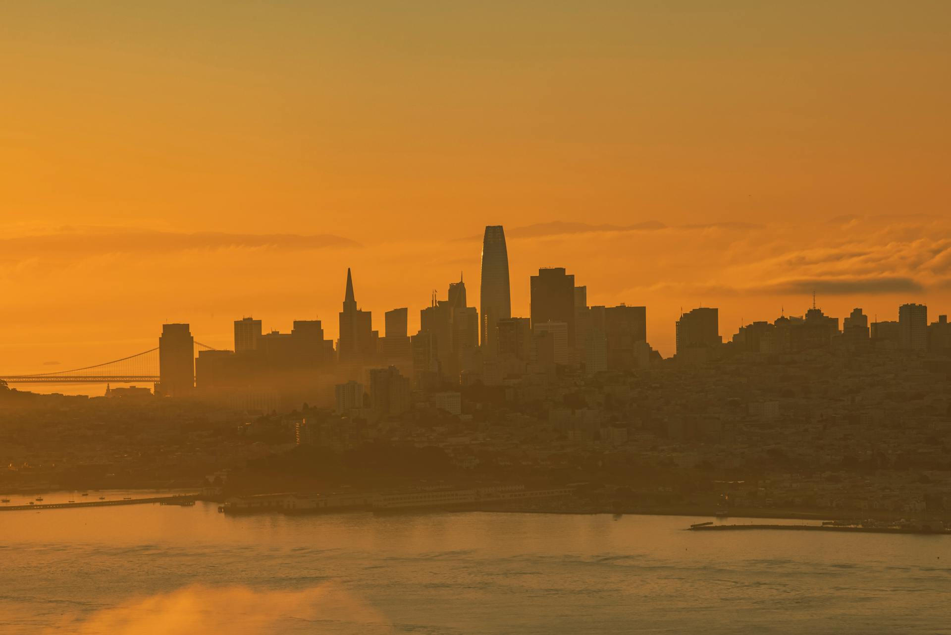 Stunning sunset over San Francisco skyline with iconic landmarks silhouetted.