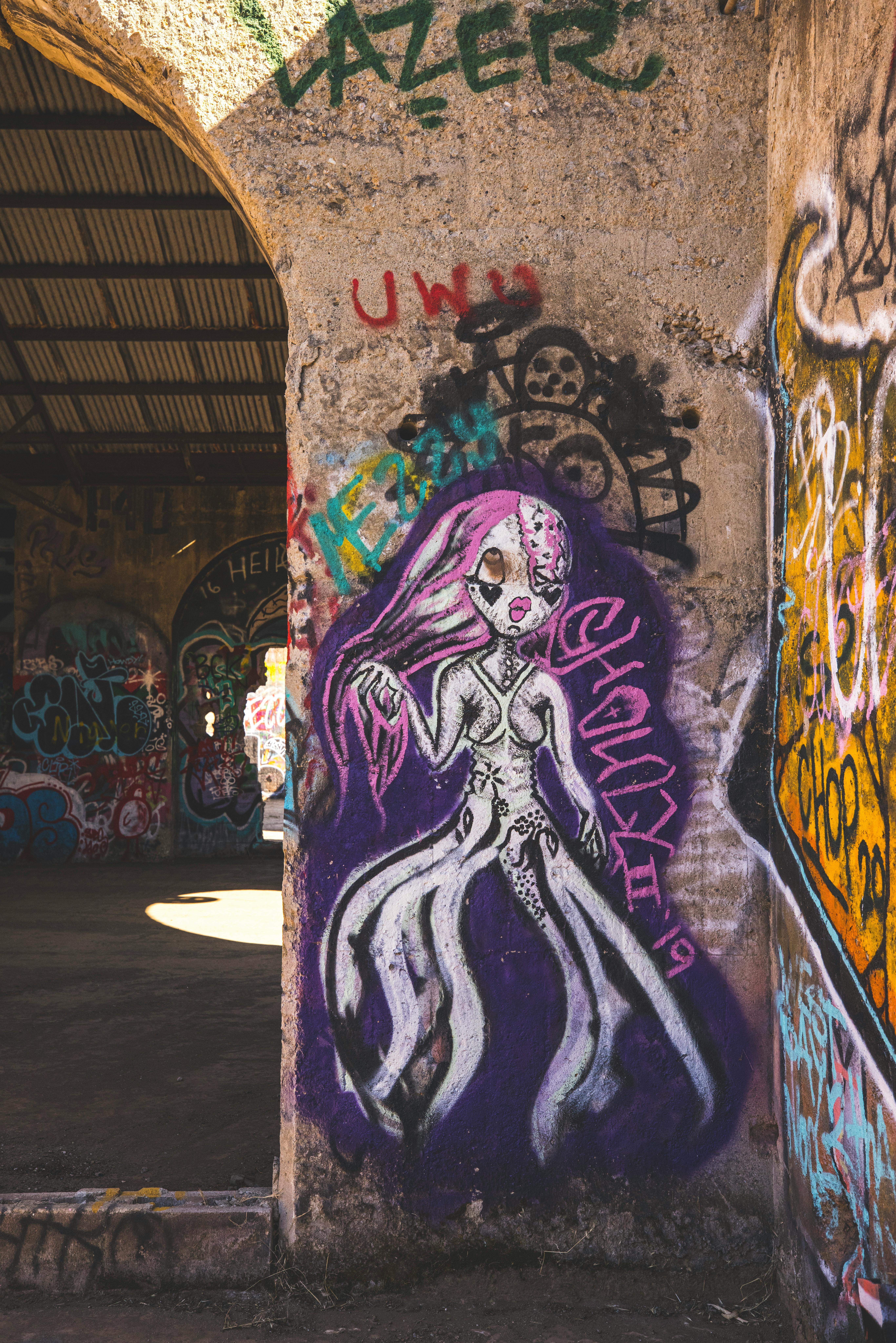 Colorful graffiti artwork on a wall inside an abandoned warehouse, showcasing urban street art.