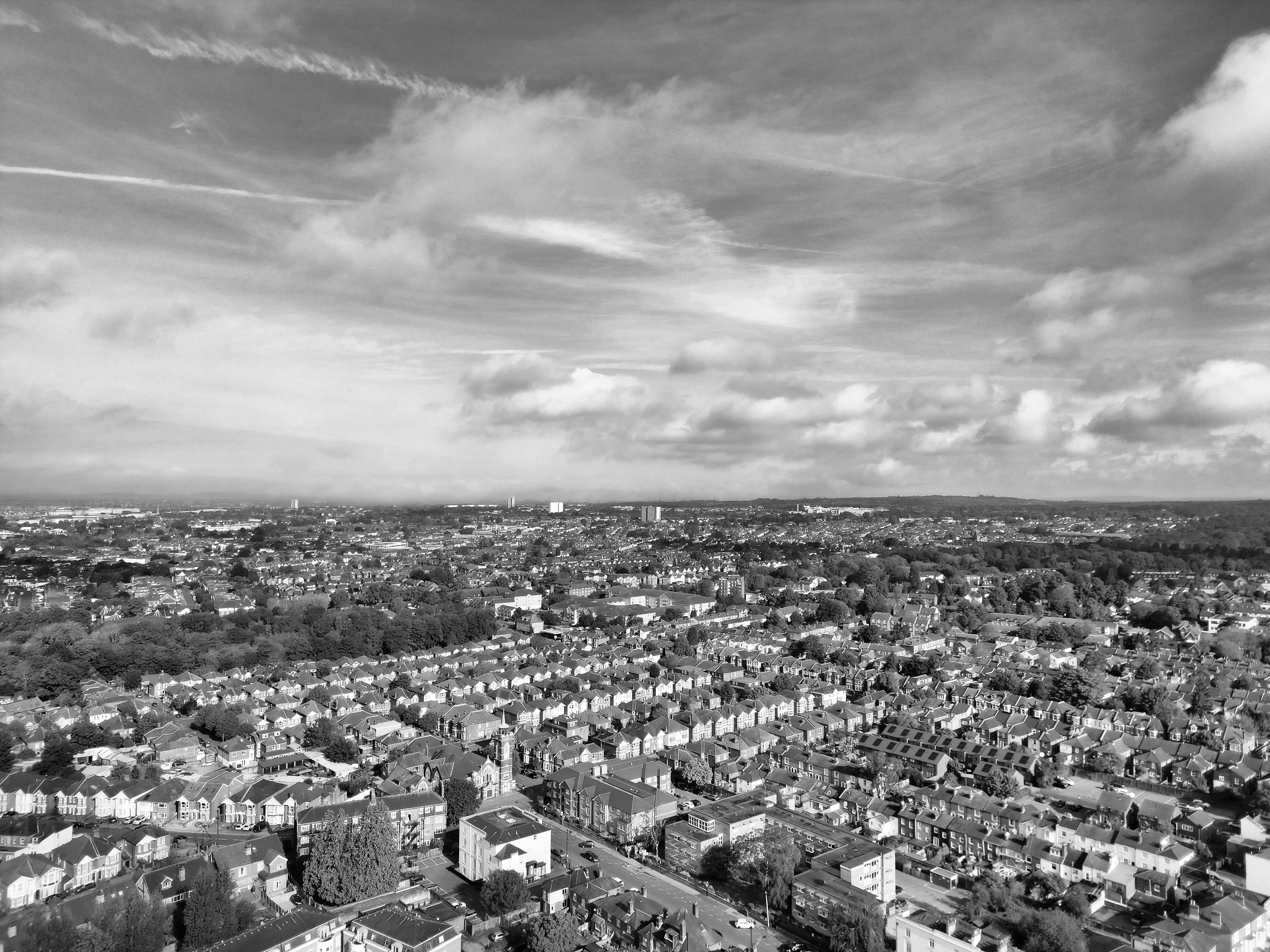 Monochrome aerial view of Southampton suburbia with scattered clouds above.