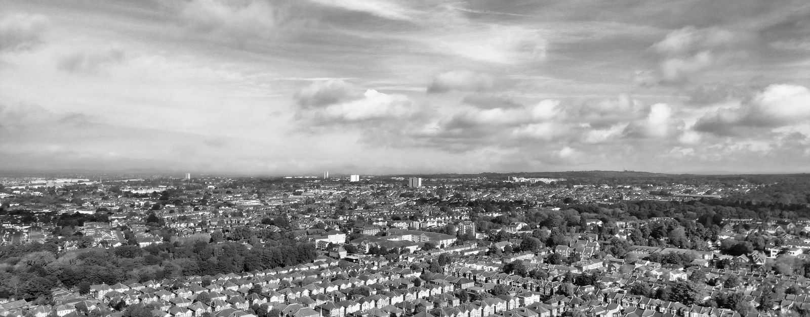 Monochrome aerial view of Southampton suburbia with scattered clouds above.