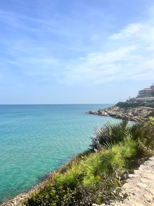 Free Breathtaking view of a clear blue sea with a rocky coastline under a sunny sky. Stock Photo