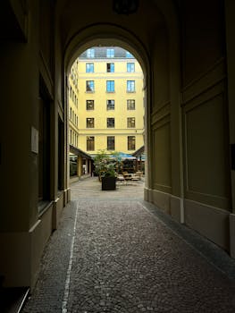 Charming view through an archway into a quiet courtyard in Munich, Germany.