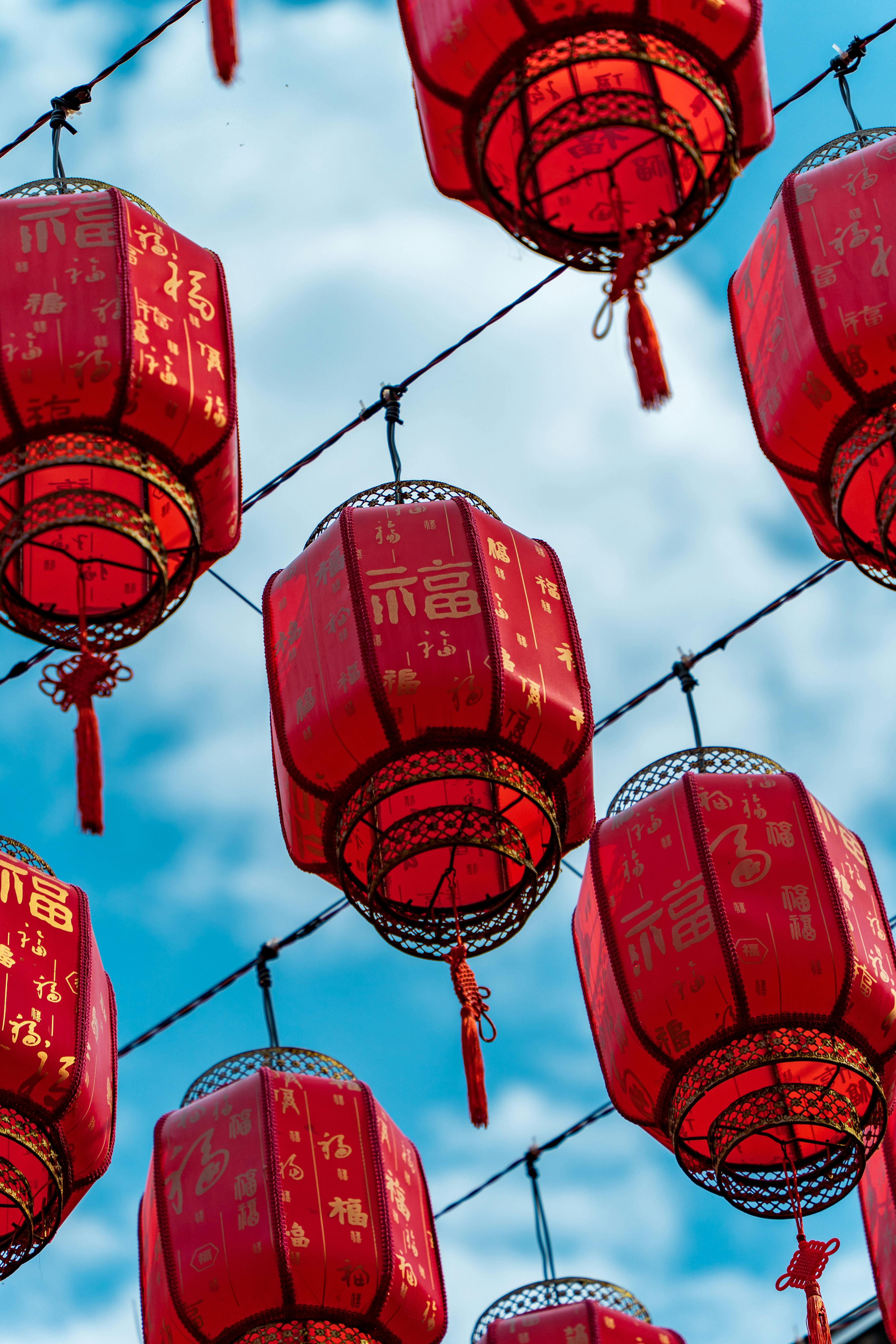 Vibrant red Chinese lanterns hang beautifully against a bright blue sky, enhancing festive spirit.