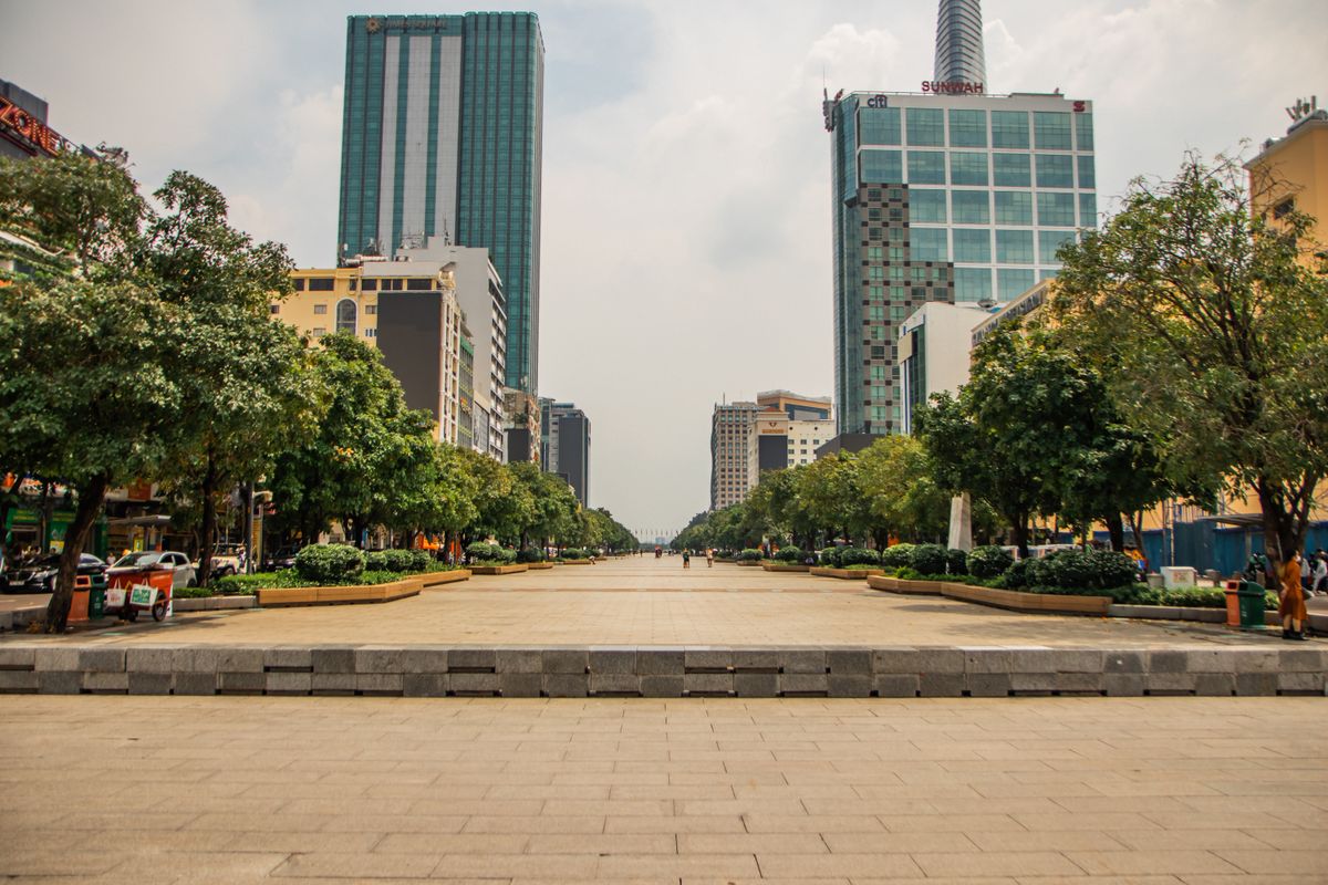 Tree-lined Nguyen Hue Walking Street with central Ho Chi Minh City buildings