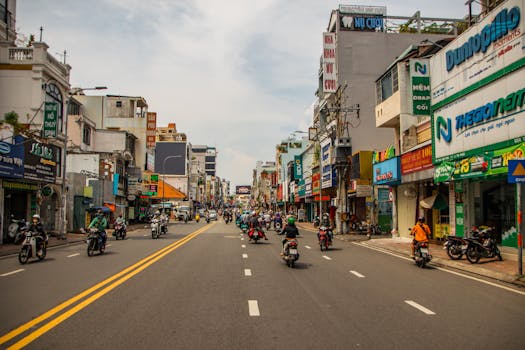 Vibrant street view of motorbikes and shops in Ho Chi Minh City, showcasing urban life.