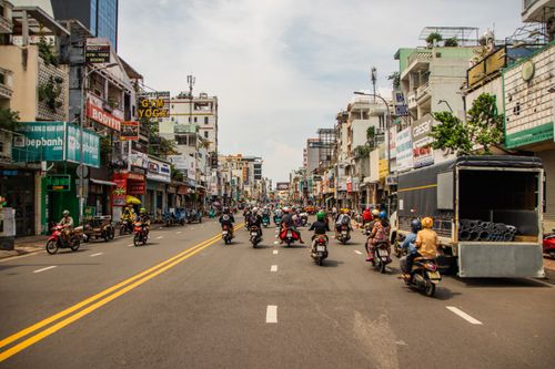 Free Motorcyclists navigating busy street in vibrant Ho Chi Minh City. Stock Photo