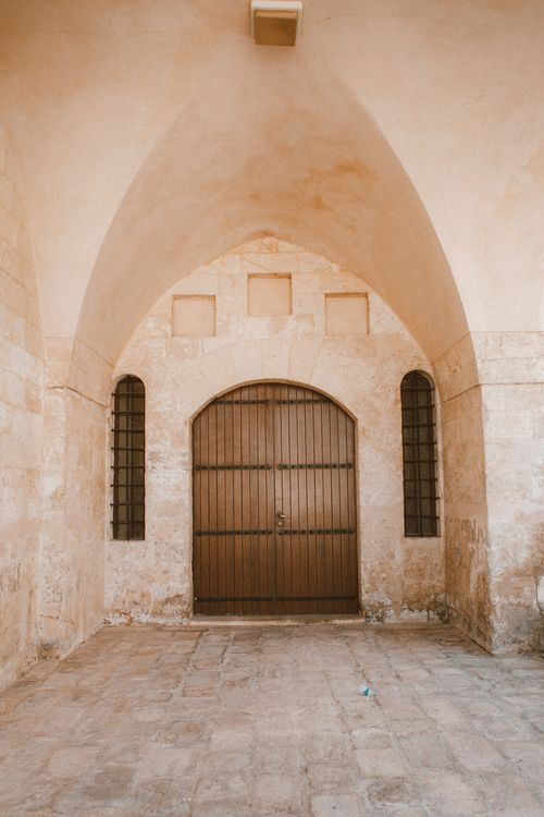 Free A historic stone archway with a wooden door in Mardin, Türkiye, showcasing classic architecture. Stock Photo