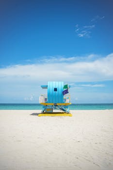 Colorful lifeguard hut on sunny Miami Beach with clear sky and ocean view.
