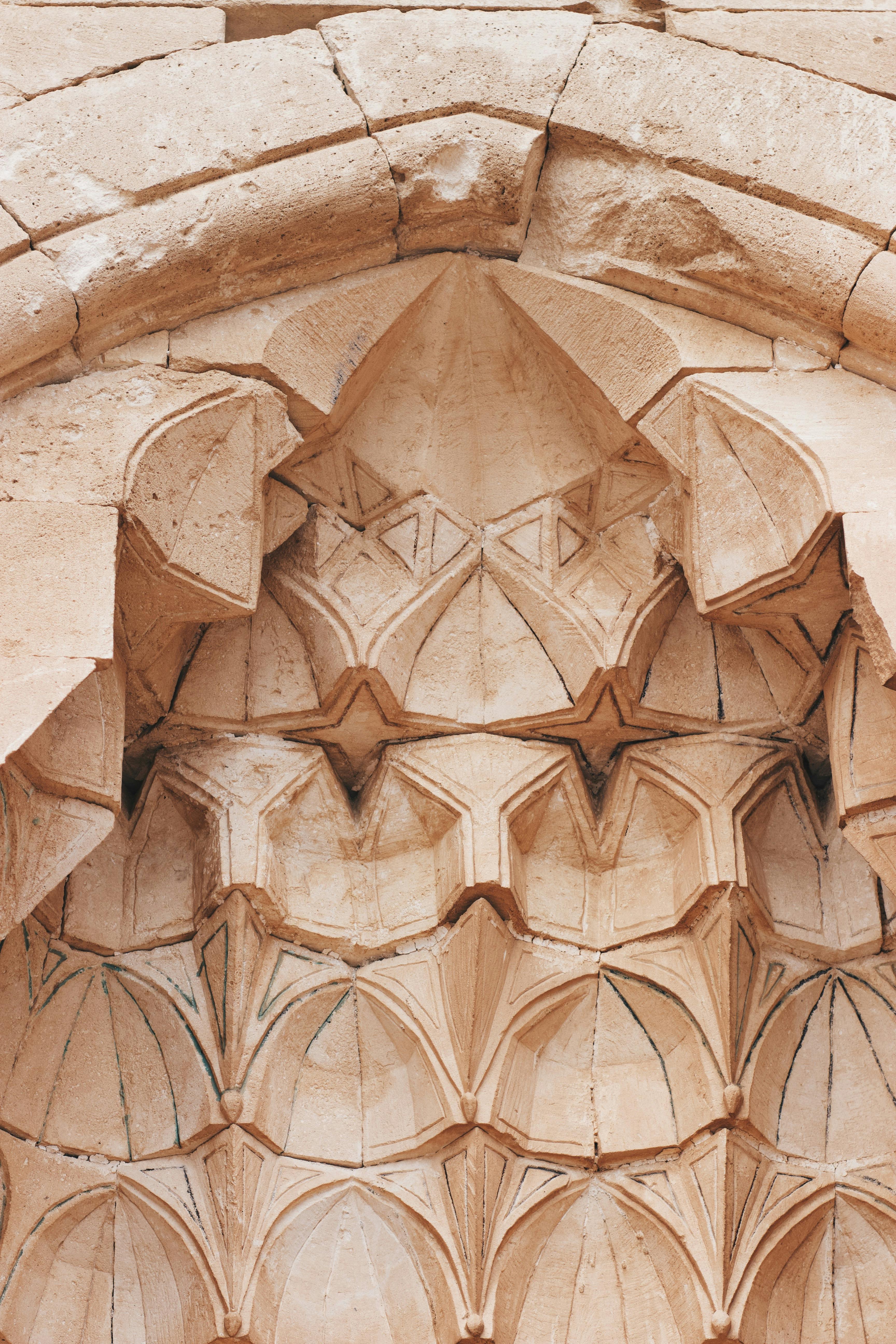 Close-up of ornate stone carving with geometric patterns in an archway.