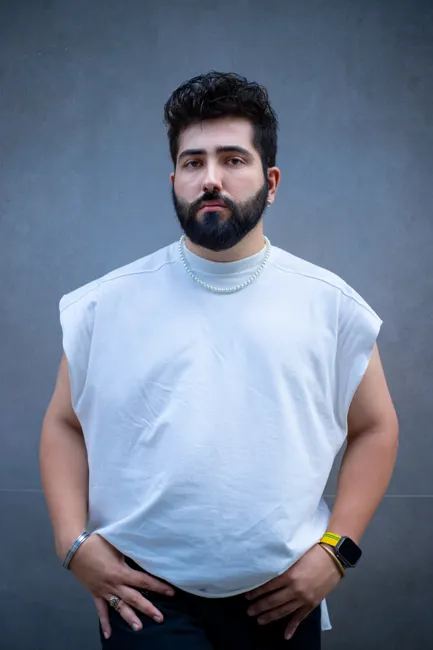 Homme en débardeur oversize blanc en coton épais, épaules tombantes, fond studio gris