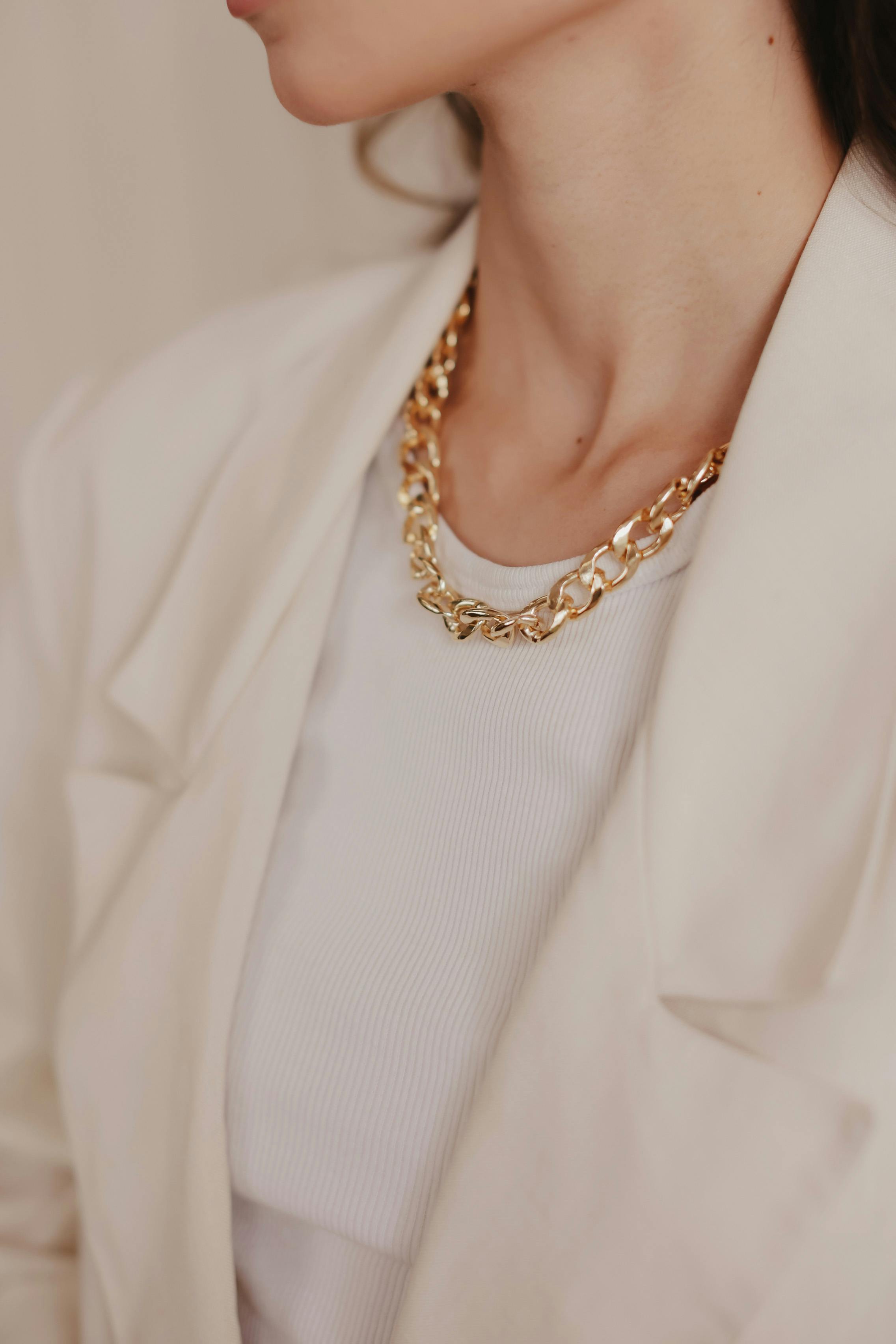 elegant gold chain necklace on white blazer