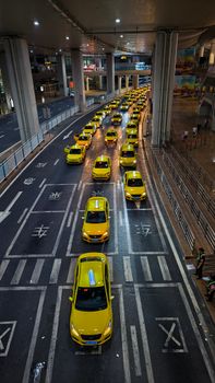 Aerial view of yellow taxis lined up under illuminated streets at night in Chongqing.