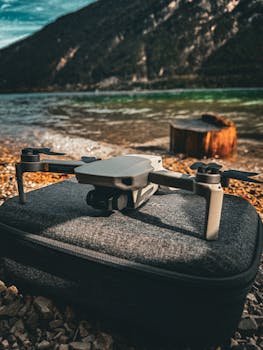 Aerial drone resting on rocky shore of picturesque lake in Tyrol, Austria surrounded by mountains.